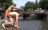 Expedia.com zwemt met medewerkers door grachten van Amsterdam